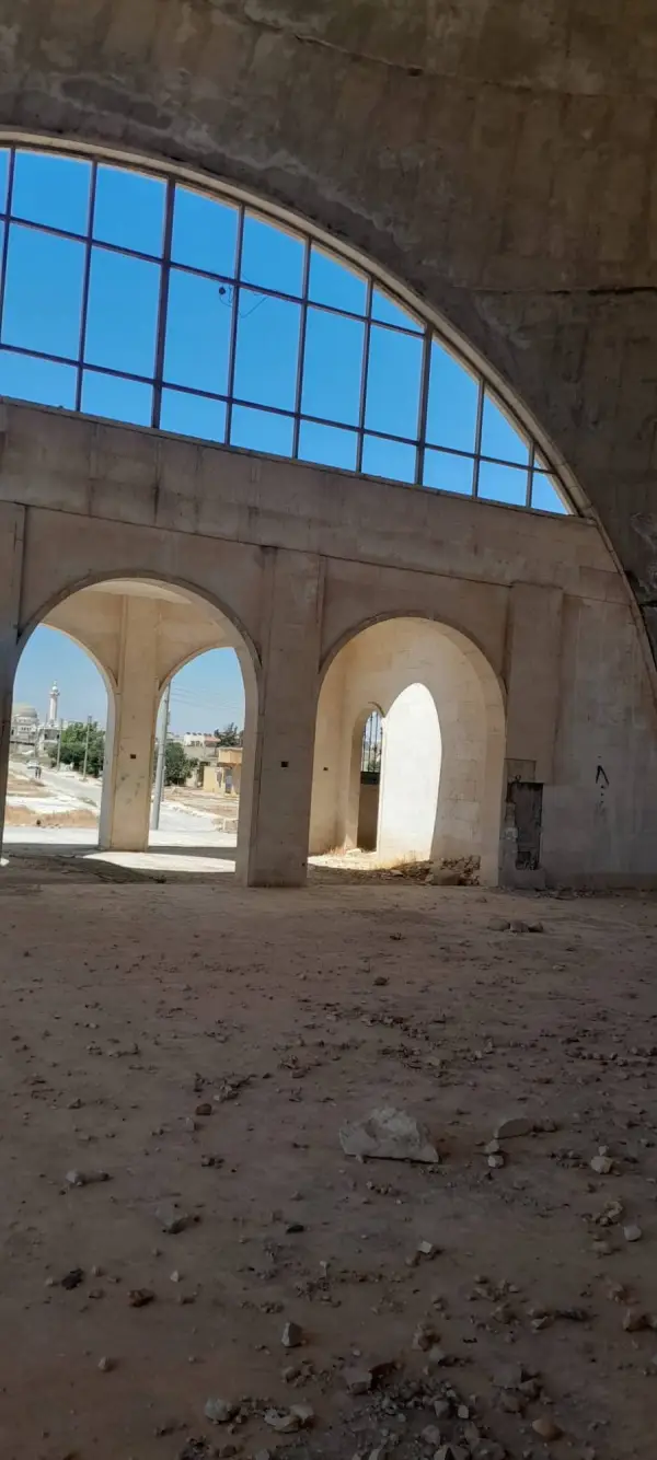 Prayer hall interior looking out through the arches, a distant minaret visible