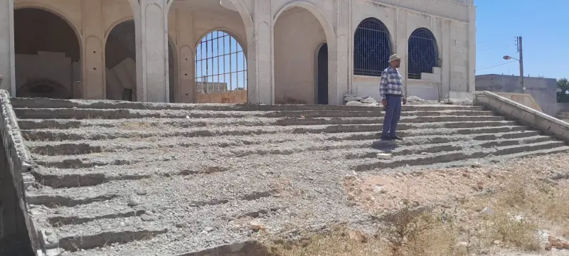 A visitor standing on the damaged front steps